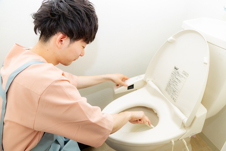 便器をブラシで掃除している様子